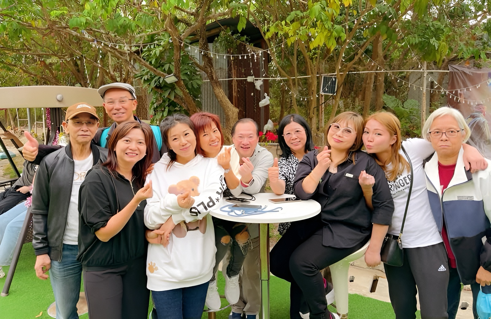 一群受助者與弟兄姊妹在戶外聚會中歡樂合照